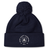 Introducing the New Saint Andrews College Pom Pom Beanie by Canterbury: a navy blue knit beanie with a playful pom-pom on top, featuring the white New Saint Andrews RFC logo embroidered on the cuff. Brought to you by EMB Canterbury.