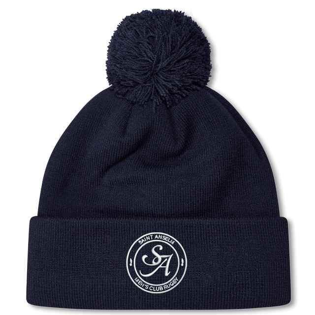 The Saint Anselm College Club Rugby Pom Pom Beanie by EMB Canterbury is a navy blue beanie with a pom-pom, featuring an embroidered white "SA" logo and "Saint Anselm Men's Club Rugby" text on the front cuff.