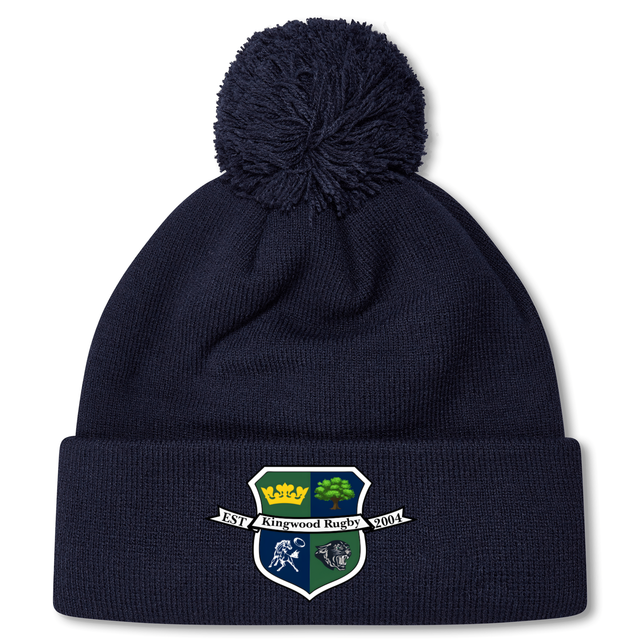 Stay warm and show team pride with the Kingwood Rugby Pom Pom Beanie by EMB Canterbury—a navy knit beanie with fleece lining, pom-pom top, and a "Kingwood Rugby" crest patch on the front.