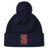 Stay warm in style with the St. Ignatius Rugby Pom Pom Beanie by EMB Canterbury, featuring a navy design, red and white "S" logo, "RUGBY" embroidery on the cuff, soft fleece lining, and playful pom-pom top.