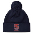 Stay warm in style with the St. Ignatius Rugby Pom Pom Beanie by EMB Canterbury, featuring a navy design, red and white "S" logo, "RUGBY" embroidery on the cuff, soft fleece lining, and playful pom-pom top.