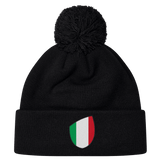 The newly arrived black Italy Shield Pom Pom Beanie by EMB Canterbury features an Italy Shield with vertical green, white, and red stripes.