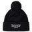 The Hornets Rugby Club 1977 Pom Pom Beanie by Canterbury from EMB Canterbury features a black knit design in the classic Canterbury bobble hat style, with a pom-pom on top and white embroidered "hornets RUGBY CLUB 1977" text on the front cuff.