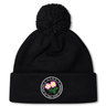The Society of Iowa Rugby Referees Pom Pom Beanie by EMB Canterbury is a black knit fleece-lined beanie topped with a pom-pom, featuring a circular embroidered patch with two pink flowers and border text, combining cozy comfort with the classic rugby beanie style.
