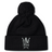 Black fleece-lined Cal Lutheran University Pom Pom Beanie by Canterbury, featuring an embroidered shield emblem with a helmet, swords, a cross, and the year 1969.