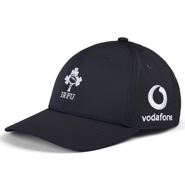 The Ireland 24 Tech Logo Cap by Canterbury is a navy blue hat showcasing the IRFU logo on the front and the Vodafone logo on the side. This cap from Canterbury also features an adjustable strap for a perfect fit.