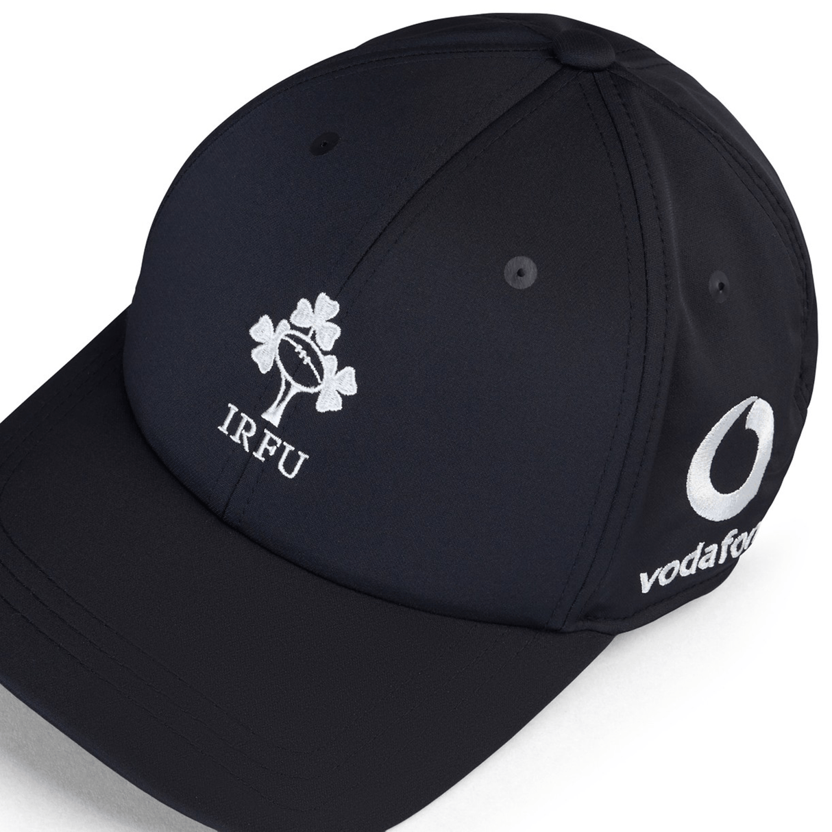 The Ireland 24 Tech Logo Cap by Canterbury features a sleek black design, showcasing the Irish Rugby Football Union (IRFU) logo along with a Vodafone logo on the side. Designed by Canterbury, it includes an adjustable strap for a perfect fit.