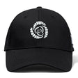 The Missoula All-Maggots Flexfit Drill Cap by EMB Canterbury features a black design with a white spiral pattern of oval shapes and an embroidered logo on the front.