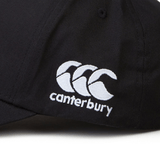 Close-up of a black Fiji Shield Flex Drill Cap by EMB Canterbury, showcasing an embroidered logo with three overlapping white curves and "Canterbury" underneath. Newly released, this cap combines classic style with modern flair, ideal for any wardrobe.