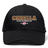 Introducing the Godzilla Rugby Football Club Flexfit Drill Cap by Canterbury from EMB Canterbury—a black cap showcasing “GODZILLA RUGBY FOOTBALL CLUB” embroidered in bold orange and white, accented by a pink flower and “1993” beneath the text on the front. Finished with a curved brim and a sleek CCC logo, this cap delivers an athletic edge to your look.