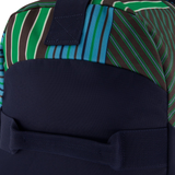 Close-up of a Canterbury Uglies Packaway Duffle Bag H125, featuring green, blue, and brown diagonal stripes with solid dark blue fabric—reinforced stitching and sturdy handle make it ideal as a stylish sports gear bag.