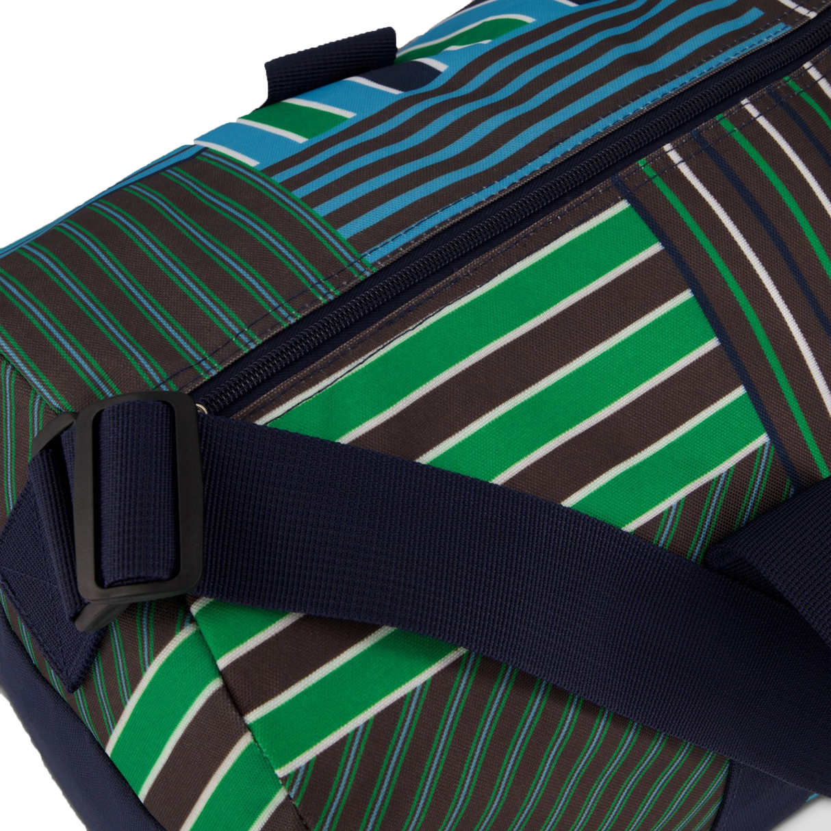 A close-up of the Canterbury Uglies Packaway Duffle Bag H125, featuring a navy strap and zipper with a geometric pattern in green, brown, white, and blue stripes.