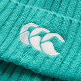 Close-up of a teal knitted fabric from the Canterbury Ireland 26 Beanie, featuring three white embroidered wave symbols.