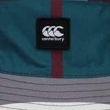 Close-up of a Canterbury logo patch on the Canterbury Uglies Red Reversible Bucket Hat, showcasing multicolored teal, maroon, grey, and white sections in a stylish reversible design.