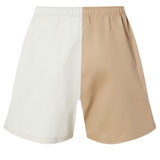 The Fundamental Harlequin Drill 3" Shorts by Canterbury feature an elastic waistband and a distinctive two-tone design—white on the left and beige on the right.