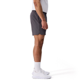 A man in profile wears a white shirt, Everest Woven Shorts by Canterbury in gray, white crew socks, and white athletic shoes against a plain white background.