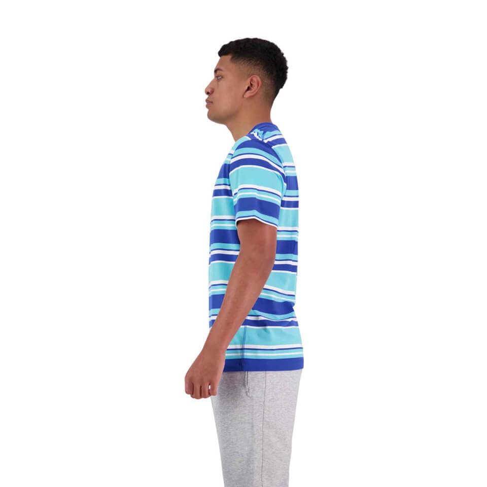 A man in a blue and white Canterbury Yarn Dye T-Shirt and gray pants stands in profile against a plain white background.
