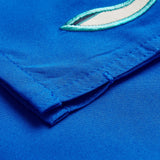 Close-up of blue Uglies Tactic Short by Canterbury, featuring visible stitching and teal and white embroidered detail near the top.