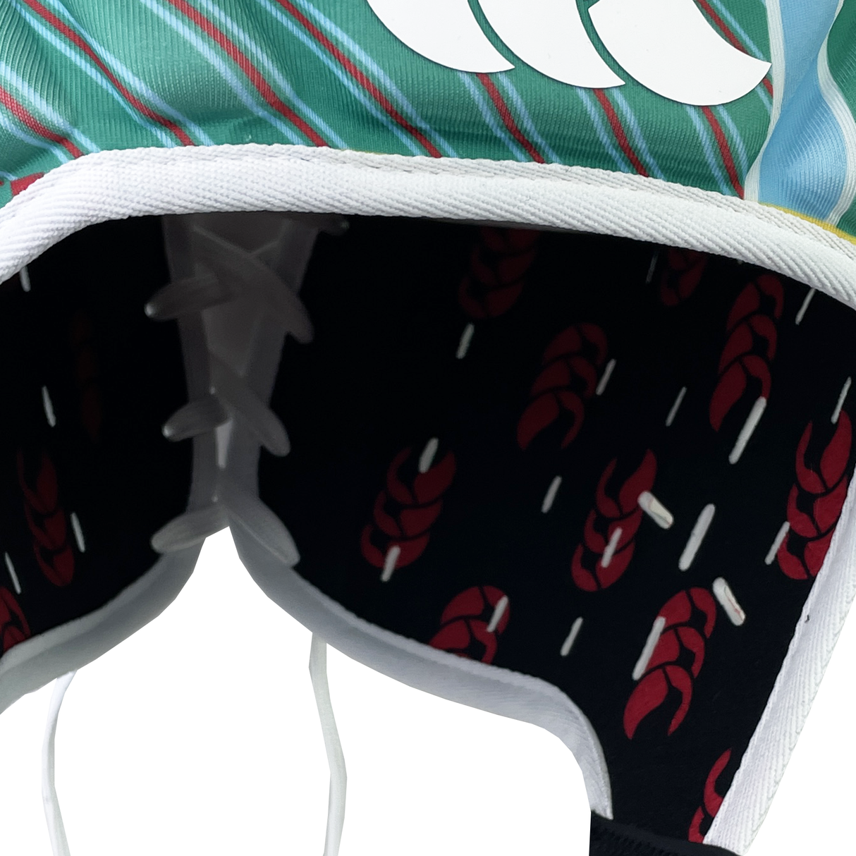 A detailed view of the vibrant Canterbury fabric from the Raze LE Uglies Headguard showcases a lace-up seam. The exterior boasts green and blue stripes with a white design, while the interior has a black base with lively red and white patterns, echoing the Raze Headguards style.