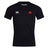 The Angry Newts Club Dry Tee by EMB Canterbury is a black short-sleeve athletic shirt featuring a white "Canterbury" logo on the right chest, a red cartoon dinosaur head on the left, and Vapodri tech for breathable comfort.