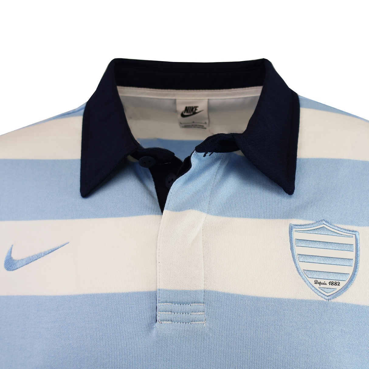 The Racing 92 25/26 Heritage Long Sleeve Rugby Jersey by Nike features light blue and white stripes, a navy collar, Nike logo on the right, and a shield emblem reading "Since 1882"—a classic, tradition-inspired piece.