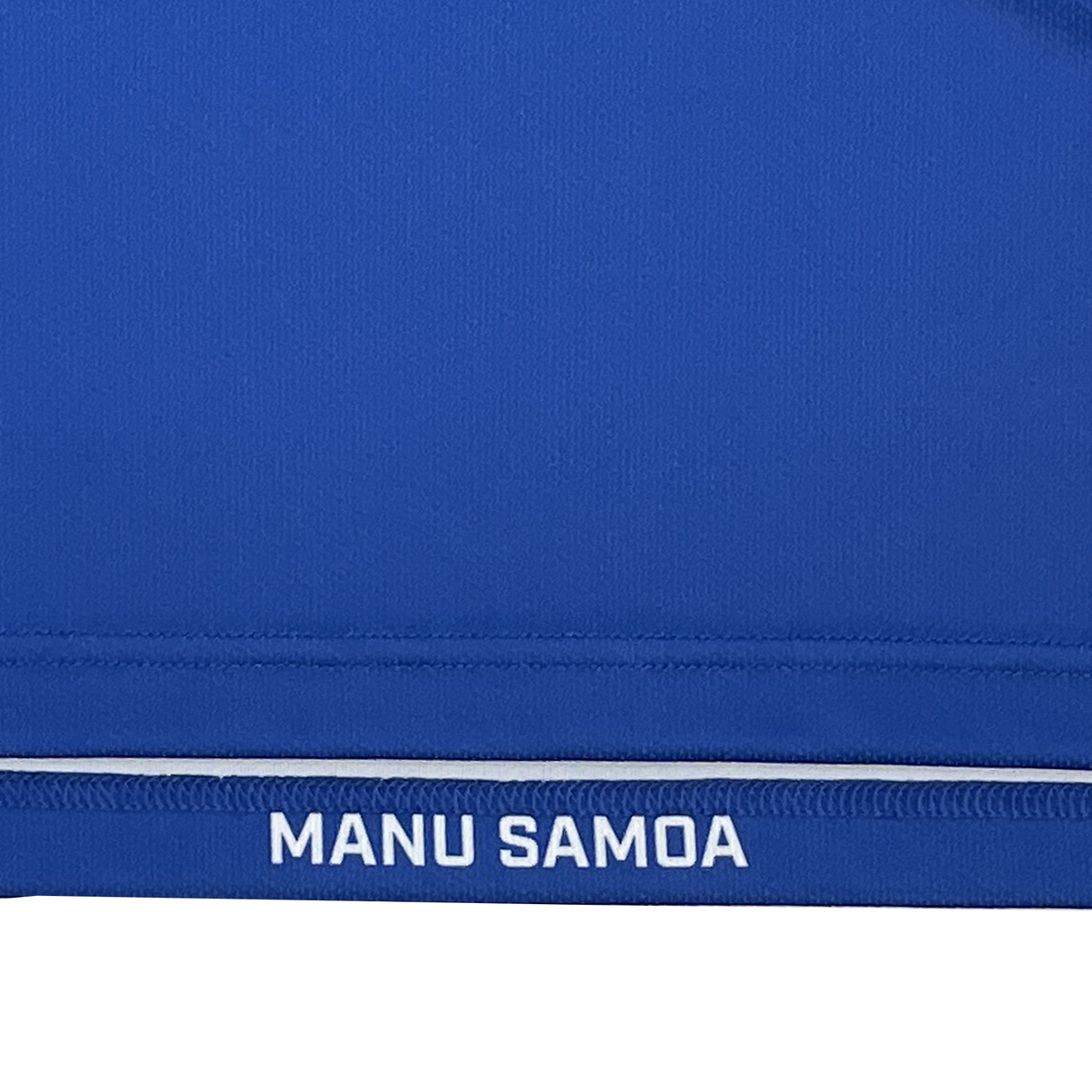 Blue fabric with white "MANU SAMOA" along the edge embodies the vibrant spirit of the Samoa 15s 24/25 Home Premium Replica Jersey by Samurai.