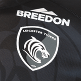 Close-up of a breathable Samurai Leicester Tigers Change Jersey 23/24 featuring the team logo and the sponsor, Breedon, on a textured black fabric.