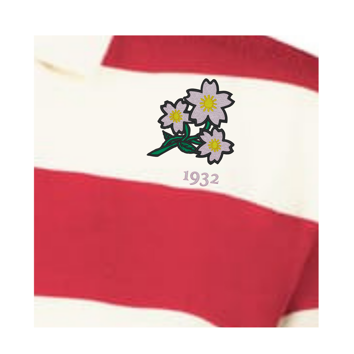 A close-up of the EMB Augusta Women's Vintage Japan Prep Street Rugby Crop, featuring red and white stripes, embroidered with three white flowers above the number "1932.