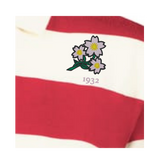 A close-up of the EMB Augusta Women's Vintage Japan Prep Street Rugby Crop, featuring red and white stripes, embroidered with three white flowers above the number "1932.