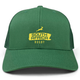 The EMB S&S Activewear Nations of Rugby South Africa Brush Stroke Retro Trucker Cap features a green design, "South Africa Rugby" lettering, yellow springbok logo on the front, and an adjustable snapback closure.