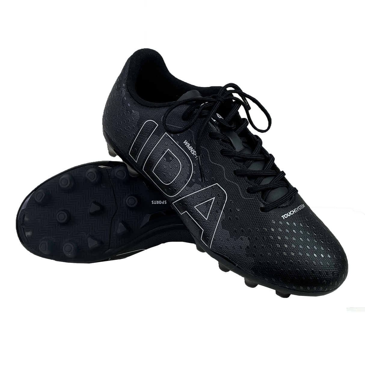 A pair of black Ida Women's Rise Club FG "Stronger Together" cleats from IDA Sports, featuring textured uppers and large silver text. Made from vegan leather, one shoe is upright while the other tilts to show its adjustable studded sole.