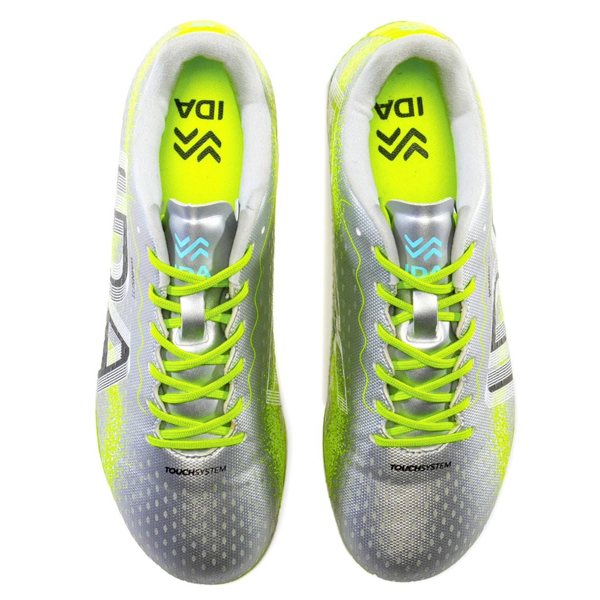 Top view of IDA Sports' Ida Women's Rise Club FG "Play All Day" cleats in silver/green, crafted from vegan leather, featuring a logo and "TOUCHSYSTEM" printed on them.