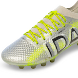 Close-up of an Ida Women's Rise Elite FG "Play All Day" soccer cleat in silver and green from IDA Sports, featuring vibrant green laces, a textured surface, black design elements, and innovative WAVEKNIT technology.