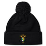 The South Side Irish 50th Anniversary Pom Pom Beanie by EMB Canterbury features a black knit, fleece lining for warmth, a large pom-pom, and an embroidered South Side Irish Rugby Chicago crest on the front cuff.