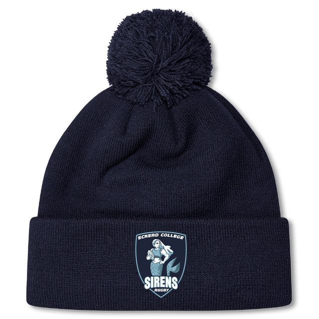 The Eckerd College Pom Pom Beanie by Canterbury, from EMB Canterbury, is a navy blue rugby hat with a fleece-lined interior, front cuff logo patch, and pom-pom on top.