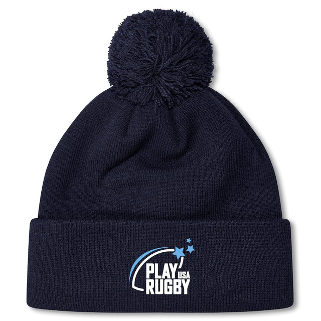 Stay warm on game days with the Play Rugby USA Pom Pom Beanie by EMB Canterbury, featuring a navy blue design, cozy fleece lining, and a white-and-blue "Play Rugby USA" logo on the cuff.