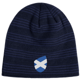 The EMB Canterbury Scotland Shield Beanie is a navy blue knit hat featuring horizontal stripes and a small blue and white shield emblem with the Scottish flag.