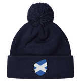The Scotland Shield Pom Pom Beanie by EMB Canterbury, in navy blue, features a Scottish flag emblem on the front, offering warmth and national pride.