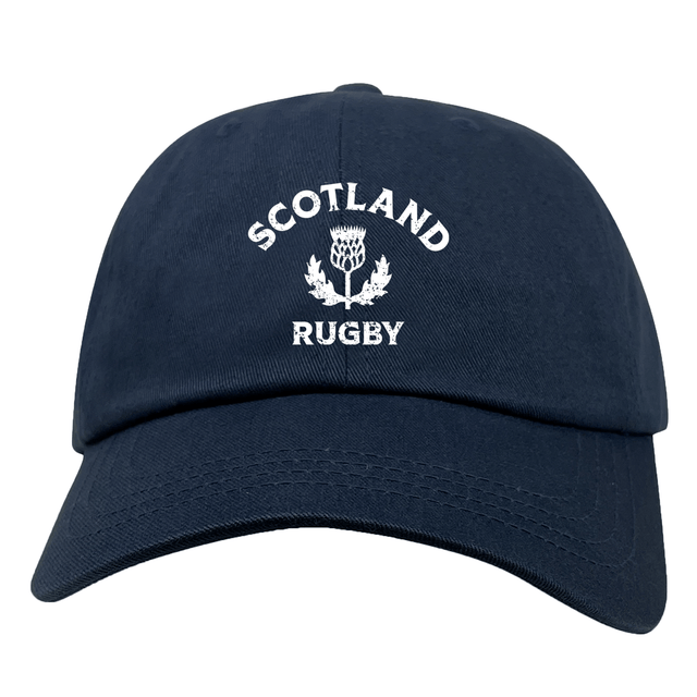 The EMB S&S Activewear Nations of Rugby Scotland Dad Cap is a navy blue cotton twill hat with "Scotland Rugby" and a white thistle emblem embroidered on the front.