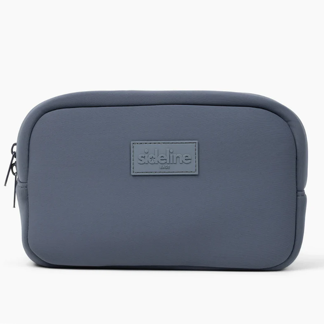 The Original Side Line Bag by SLB is a rectangular, gray waterproof neoprene pouch with a front "SLB" logo patch and zip closure, ideal for female athletes. Shown against a plain white background.
