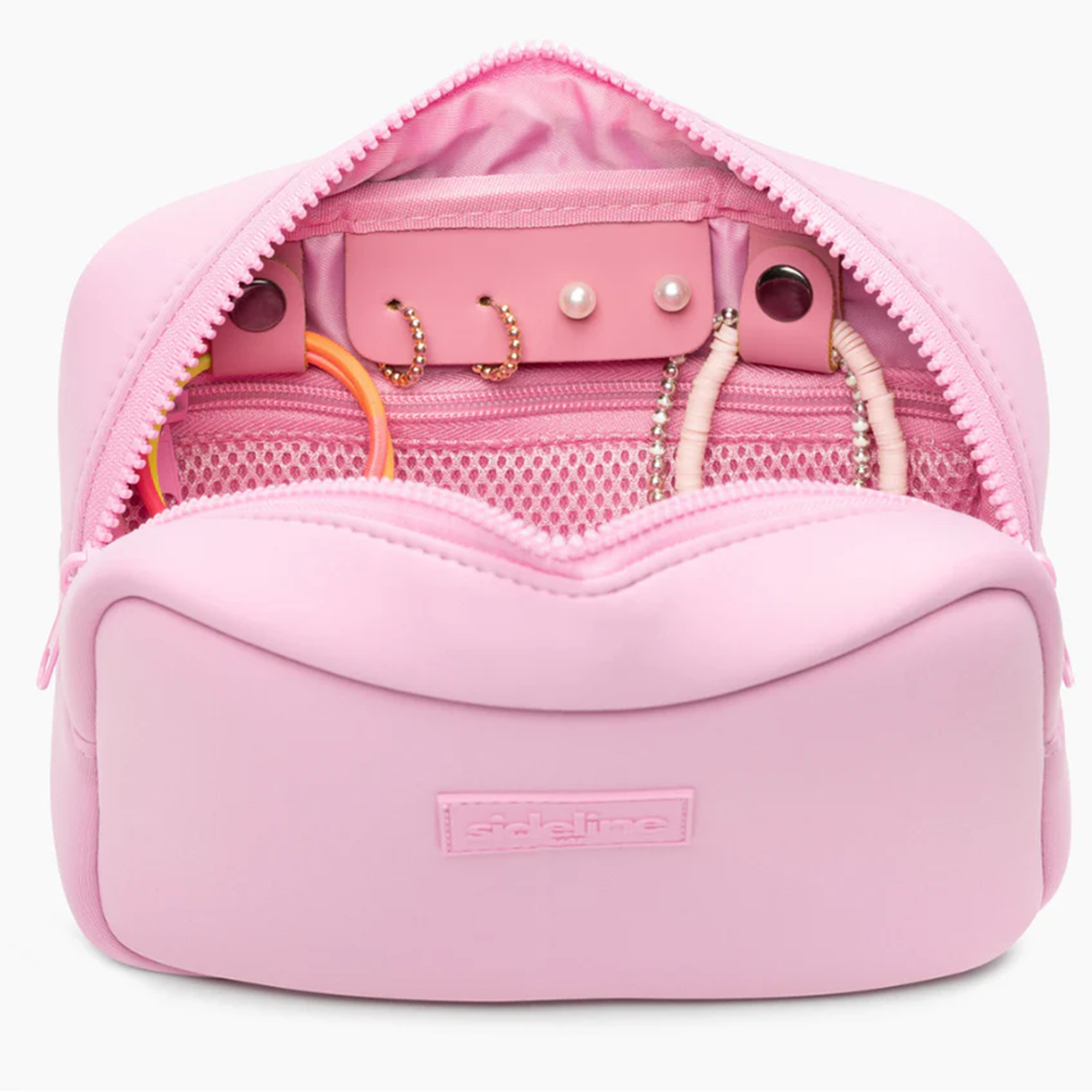 The Original Side Line Bag by SLB is a light pink waterproof neoprene organizer, shown open with hoop earrings, a beaded bracelet, bangle, and pearl studs in compartments—perfect for female athletes to store jewelry.