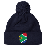 The EMB Canterbury South Africa Shield Pom Pom Beanie is a navy blue beanie featuring a patch with the iconic South Africa Shield design on the front.