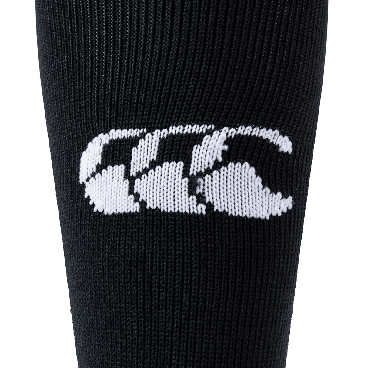 Close-up of black fabric with a white, three-part, stylized logo resembling three intertwined letters "C," embroidered in the center. The intricate design showcases the craftsmanship often found in the Canterbury Playing Sock by Canterbury, highlighting attention to detail.