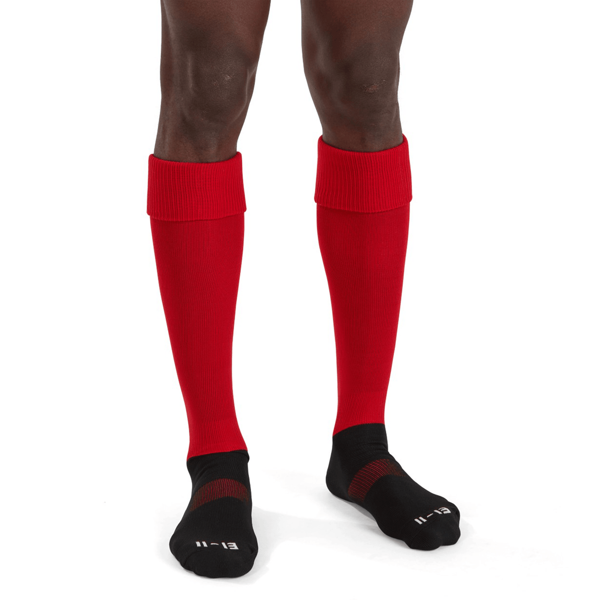 A person stands wearing Canterbury Playing Socks in bright red, pulled up to the knee over black ankle socks, visible from the knee down against a plain white background.