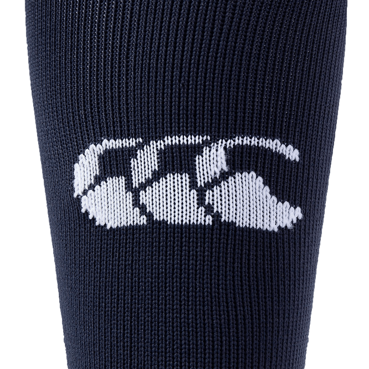 Close-up of a navy blue knit fabric featuring a white Canterbury logo with three overlapping shapes resembling sideways Cs, reminiscent of the design found on premium Canterbury Playing Sock.