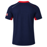 Women's USA Rugby Pro Away Jersey 22/23 by Castore: navy short-sleeve jersey with a red collar, red sleeve accents, white and red stitching, and an American flag patch on the right sleeve. Back view.