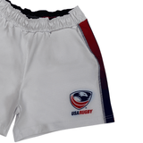 The Women's USA Rugby Pro Home Shorts by Castore are made with moisture-wicking fabric, an elasticated waistband for comfort, and adorned with the iconic "USA Rugby" logo and bold red and blue side stripes.