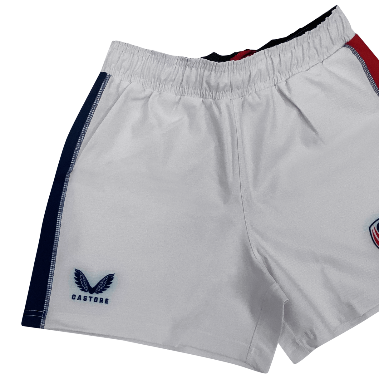 Women's USA Rugby 22/23 RWC Pro Home Shorts by Castore feature a white design, elastic waistband, blue side panel, and embroidered Castore logo on the left leg with red and blue badge detail—ideal for women's rugby fans.