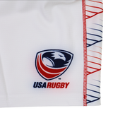The Women's USA Rugby 22/23 RWC Home Pro Short by Castore features a white base, the USA Rugby eagle head logo with red, white, and blue accents, plus a geometric red and blue line pattern on the side.