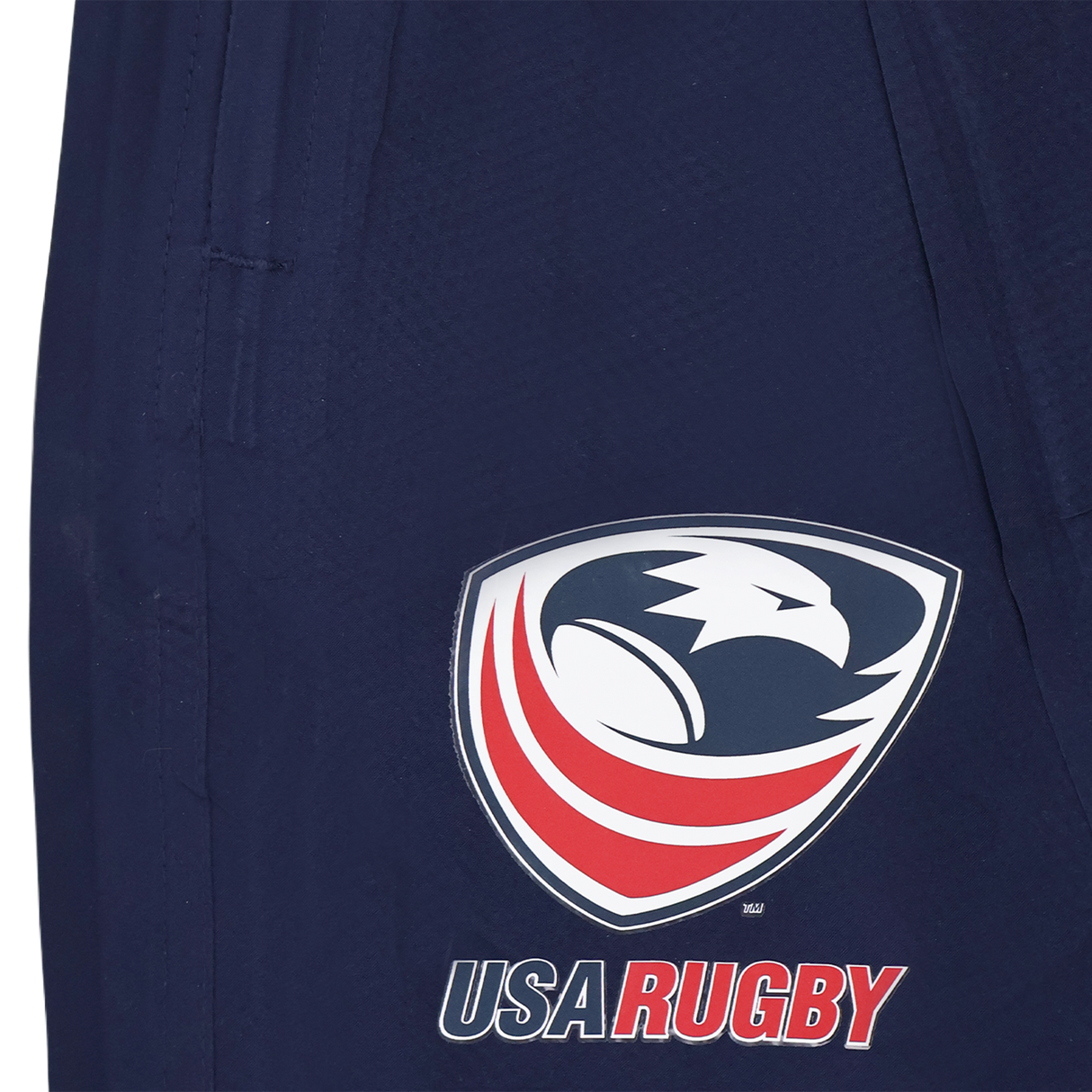 The Womens USA Rugby Weather-resistant Pant by Castore features navy blue fabric and the USA Rugby logo—an eagle head above red and white curves with "USA RUGBY" below—perfect for fans seeking style and weather protection.